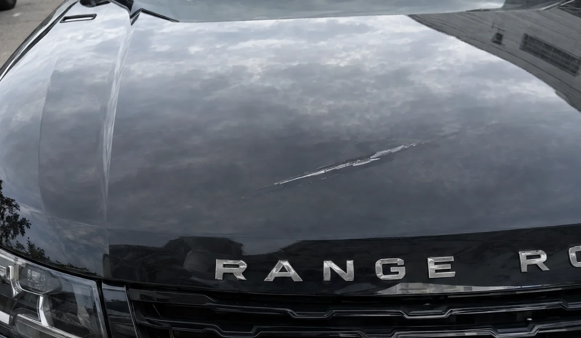Originales Schadenfoto der Range-Rover-Motorhaube mit Kratzer, dokumentiert in DIO.